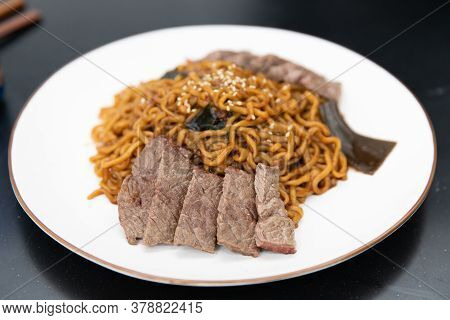 Korean Black Bean Sauce Noodles With Saliced Meat On A Plate.