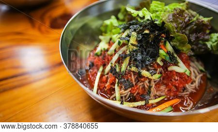 Close Up Image Of Korean Traditional Food, Spicy Cold Soba Noodles, Bibim Guksu, On A Stainless Stee