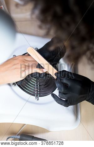 Manicurist Master In Black Mask And Gloves Making Manicure For A Client With A Nailfile