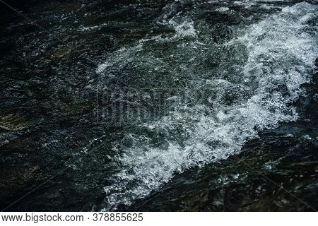 Nature Background Of Dark Water Stream Of Mountain River With Rapids. Full Frame Of Sea Surf. Natura