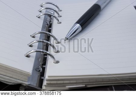 On An Open Notepad With Rings And Sheets In A Ruler Is A Ballpoint Pen