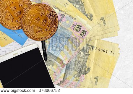 1 Ukrainian Hryvnia Bills And Golden Bitcoins With Smartphone And Credit Cards. Cryptocurrency Inves