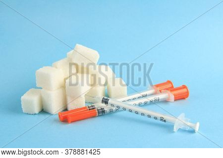 Diabetes Day On 14 November. Insulin Syringes And Sugar On A Blue Medical Background. Copyspace.