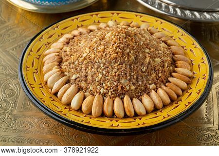 Dish with traditional Moroccan homemade sellout decorated with roasted almonds close up