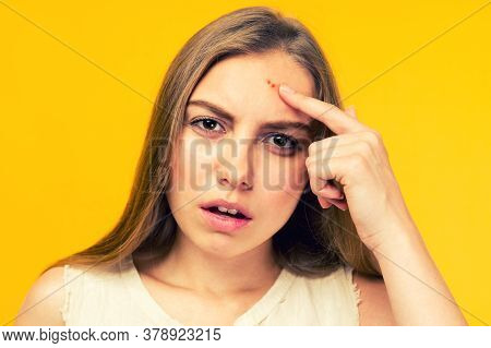 Portrait Of Sad Teen Gerl Touching Her Face And Looking For Acne On Yellow Background