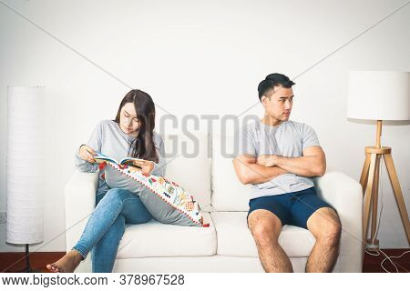 Couples Just Married, Quarrel, Refusing To Talk To Each Other. Both Were Sitting On The Sofa Inside 
