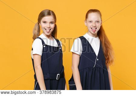 Two Young Little Girls 12-13 Years Old In White T-shirt Blue School Uniform Dresses Isolated On Yell