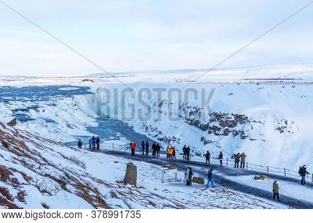 Gullfoss, Iceland - March 4, 2020: Tourists At Observation Deck Look At Gullfoss Waterfall. People A