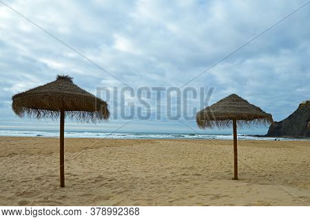 Two Sunshade On The Beach In Odeceixe On The Atlantic Coast Of Portugal