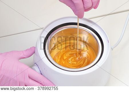 Wax For Hair Removal. Molten Wax In A Special Container For Heating The Wax. Preparing A Warm Golden