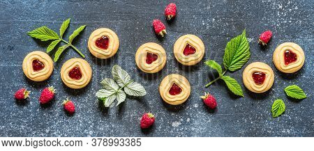Shortbread Butter Cookies With Raspberry Jam Filling Center, Fresh Berries And Leaves, Blue Concrete