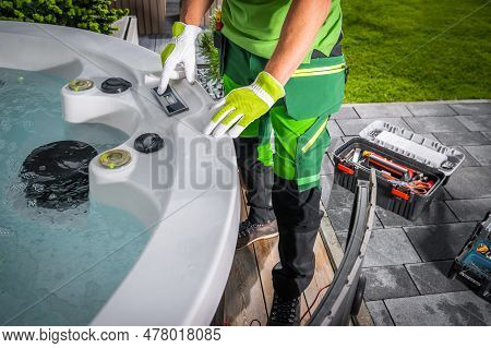 Professional Hot Tub Technician Performing Regular Check And Maintenance Of Outdoor Jacuzzi At Resid