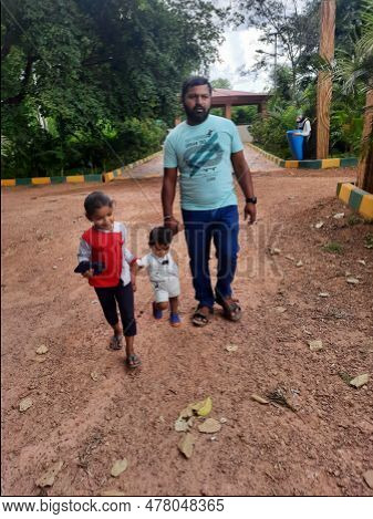 Indian Father With Daughter And Toddler Boy Kid Walking And Sitting In A Machohalli Forest Gate.