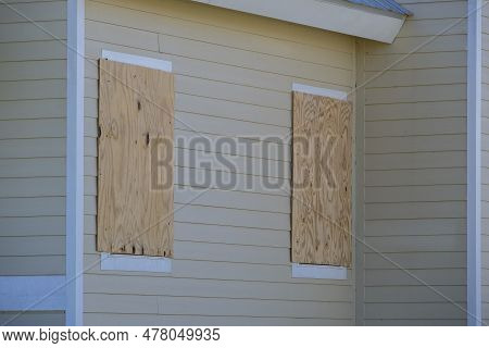 Hurricane Shutters Made From Plywood Mounted For Protection Of House Windows. Protective Measures Be