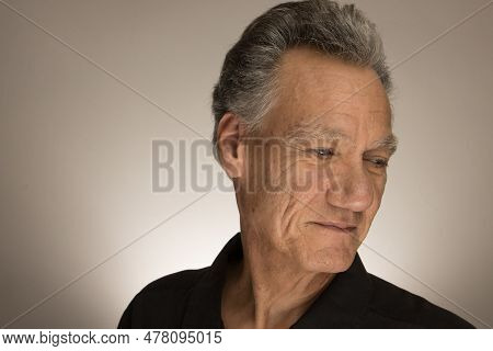 Portrait Of A Mature Man With Graying Hair Wearing A Black Shirt 60plus Looking Down