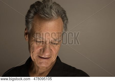 Portrait Of A Mature Man With Graying Hair Wearing A Black Shirt 60plus Looking Down