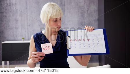 Woman Using Menstrual Cycle Or Period Calendar