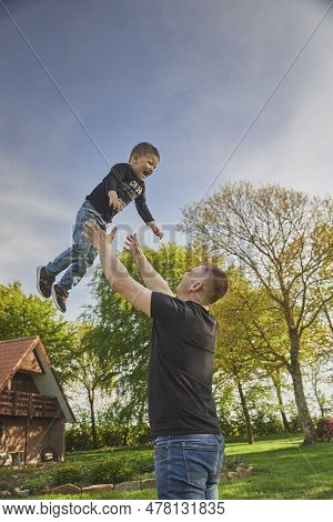 Skjern, Denmark, May 21, 2023: Father Playing With Son In The Yard