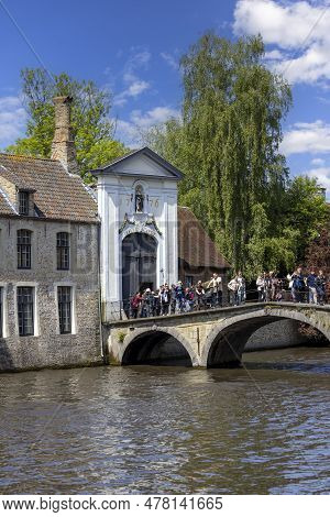 Bruges, Belgium - May 19, 2023: Tourists On The Beguinage Bridge Over Water Channel In Front Of Begu