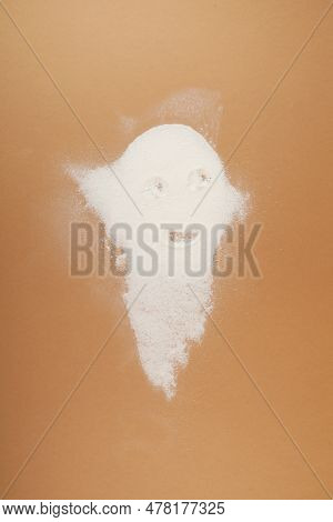 Pile Of White Powder In The Shape Of Ghost On Beige Background. Concept Of Harmful Food And Food Add