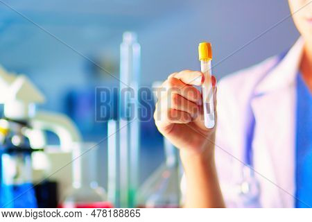 Female Medical Or Research Scientist Or Doctor Using Looking At A Test Tube Of Clear Solution In A L
