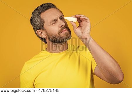Man With Eyecare Medicine Isolated On Yellow. Man With Eyecare Medicine On Background.