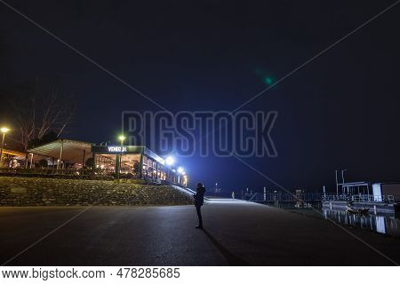 Belgrade, Serbia - March 5, 2023: Selective Blur A Woman, Alone, Standing On The Riverbanks Of River