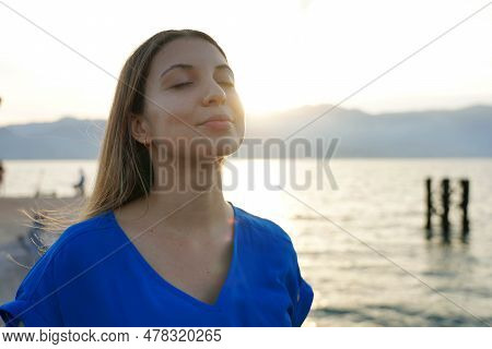 Portrait Of Meditative Woman Breathing On Sunset. Spirituality, Purity And Peace Concept.