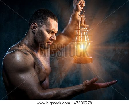 Lampa naftowa gospodarstwa muskularny mężczyzna
