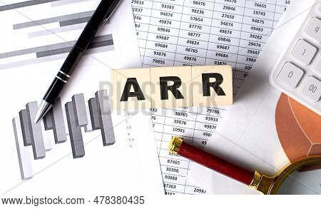 Arr Text On A Wooden Block On Graph Background With Pen And Magnifier