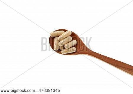 Hulbah Pills In Wooden Spoon, Close-up. Hulbah Pills Help Reduce Discomfort And Menstrual Cramps Ass