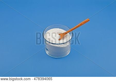 Sodium Benzoate, Sodium Salt Of Benzoic Acid In Glass Dish On Blue Background. White Crystalline Pow