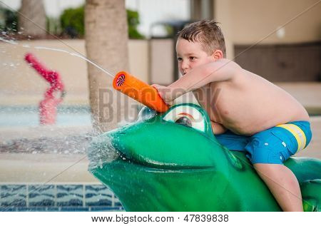 Bambino che gioca con il giocattolo di acqua presso la piscina per bambini durante l'estate
