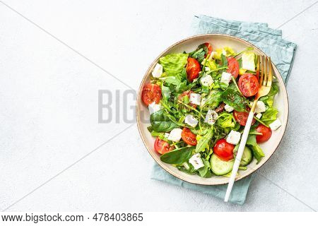 Green Salad With Spinach, Arugula, Tomatoes And Feta With Olive Oil. Top View On White.