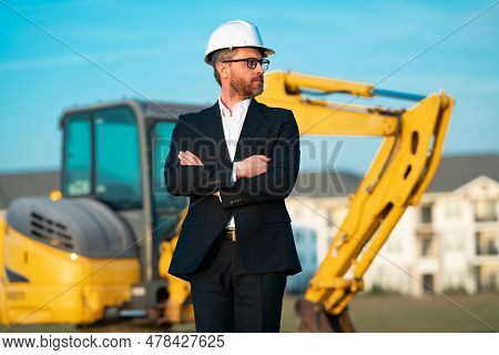 Construction Manager In Suit And Helmet At A Construction Site. Construction Manager Worker Or Super