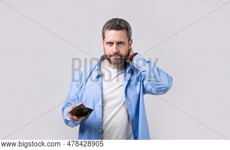 Concerned Moneyless Man With Wallet In Studio. Moneyless Man With Wallet At Hand.
