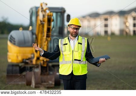 Construction Manager In Suit And Helmet At A Construction Site. Construction Manager Worker Or Super