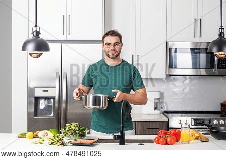 Man Chef Cooking Food In Pan Pot In Kitchen. Process Of Preparing Gourmet Dish. Man Cooking At Home 