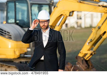 Construction Manager In Suit And Helmet At A Construction Site. Construction Manager Worker Or Super