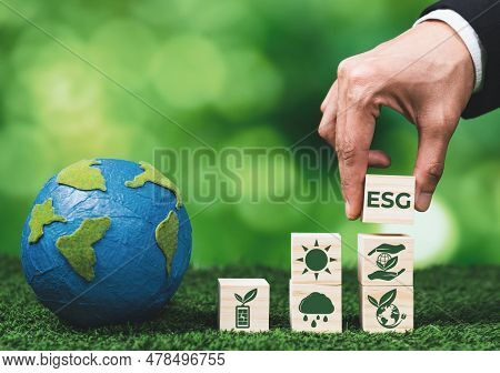 Businessman Holding Paper Earth Planet With Esg Symbol Wooden Cube. Sustainable Corporation Developm