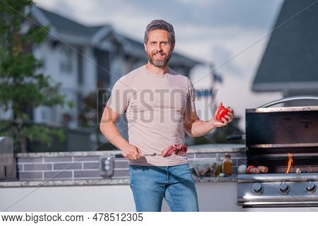 Man At A Barbecue Grill. Male Cook Preparing Barbecue Outdoors. Bbq Meat, Grill For Picnic. Roasted 