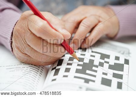 Asian Elderly Woman Playing Sudoku Puzzle Game To Practice Brain Training For Dementia Prevention, A