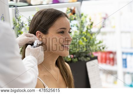 Pharmacist Uses A Specialized Piercing Gun To Create A New Earlobe Piercing
