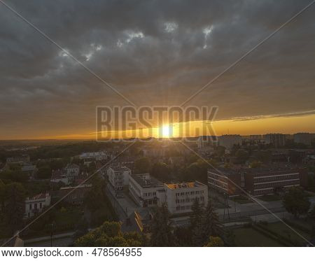 Panorama Of Ostrowiec Swietokrzyski Under The Setting Sun. Cloudy Dark Sky Illuminated By The Settin