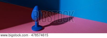 Blue Buttplug Sex Toy On A Colorful Background. Photo Of Anal Toy For Adult With Contrast Shadows