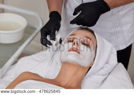 Beautician Cleanses Skin Of Woman With Cotton Sponge. .