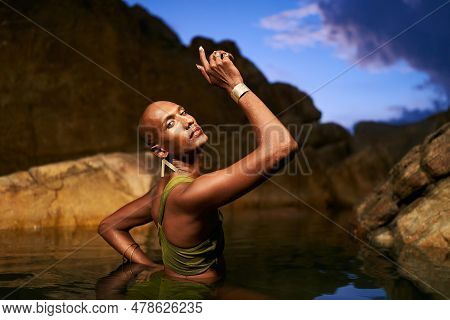 Androgynous Bipoc Lgbtq Model Poses In Water Inside Natural Pool At Night. Non-binary Person Shows J