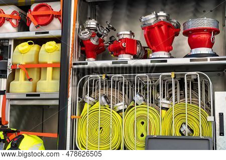 Rolled Up Yellow Fire Hoses And Various Water Taps In A Fire Track. Close-up.