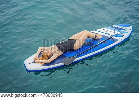 Young Women Having Fun Stand Up Paddling In Blue Water Seaamong The Rocks In Montenegro. Sup