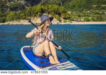 Young Women Having Fun Stand Up Paddling In Blue Water Sea Near St Stefan Island In Montenegro. Sup